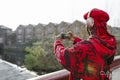 Young woman standing on bridge and taking photo