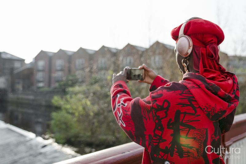 Young woman standing on bridge and taking photo