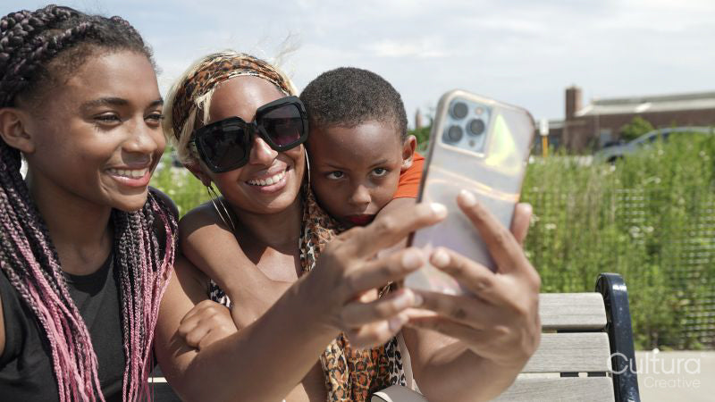 Smiling mother and children taking selfie outdoors