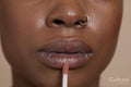 Close-up of woman applying lip gloss