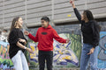 Smiling friends laughing by graffiti wall