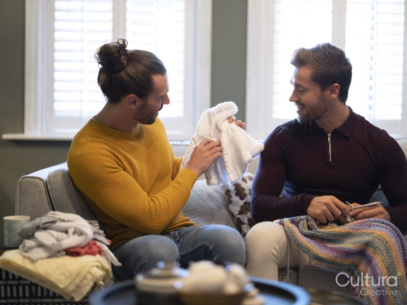 couple looking at homemade baby clothing