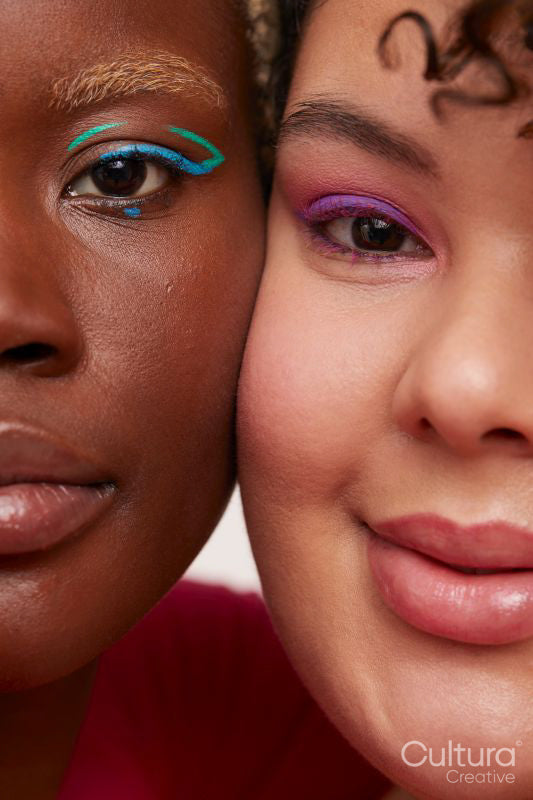 Portrait of two young women wearing make up, cheek to cheek
