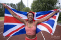 Portrait of smiling athletic woman with British flag on running track