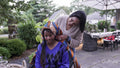 Mother putting traditional headdress on daughter