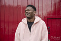 Smiling young man wearing pink hoodie