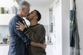 Male couple hugging and kissing at home