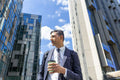 Businessman walking in business district with coffee