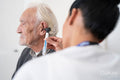 Female doctor examining patient with otoscope