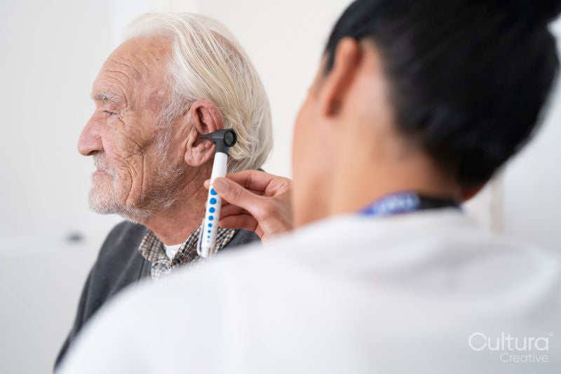 Female doctor examining patient with otoscope
