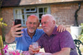 Senior male couple taking selfie