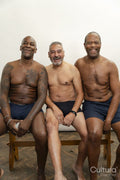 Portrait of smiling senior men without shirts against gray background