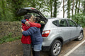 Mother and son hugging by car after hike
