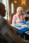 Senior woman and man talking at table during meal in nursing home