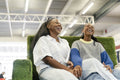 Young female couple relaxing on sofa in shopping center