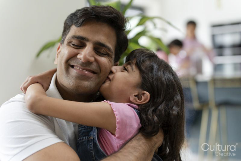 Father hugging daughter at home