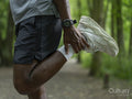 Man doing thigh stretch in forest