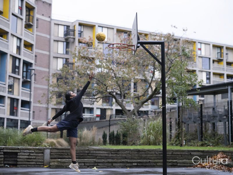 Teenage girl playing basketball outdoors