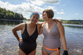 Smiling female friends standing in lake, Yorkshire, UK
