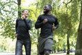 Smiling man and woman jogging in park