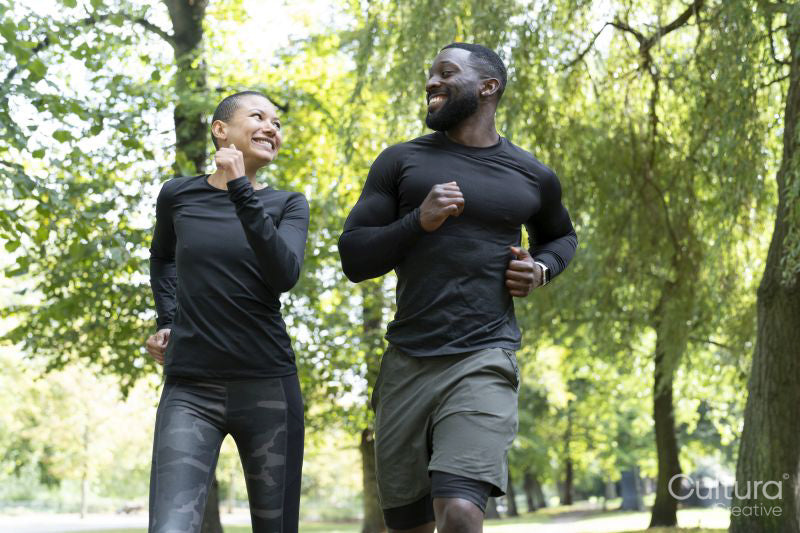 Smiling man and woman jogging in park