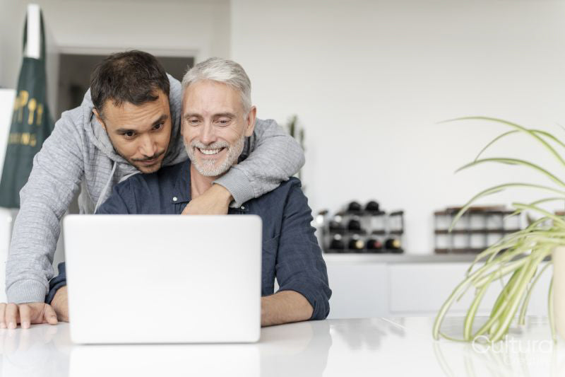 Male couple using laptop at home