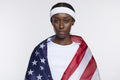 Studio portrait of athletic woman wrapped in American flag