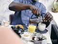 Man pouring coffee at breakfast table