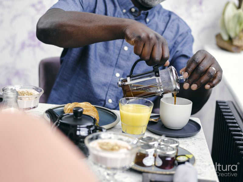 Man pouring coffee at breakfast table