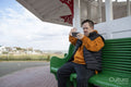 Man sitting on bench and waving to smart phone