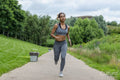 Woman with headphones jogging in nature