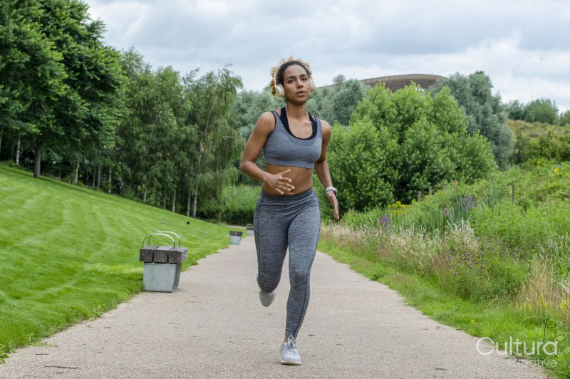 Woman with headphones jogging in nature