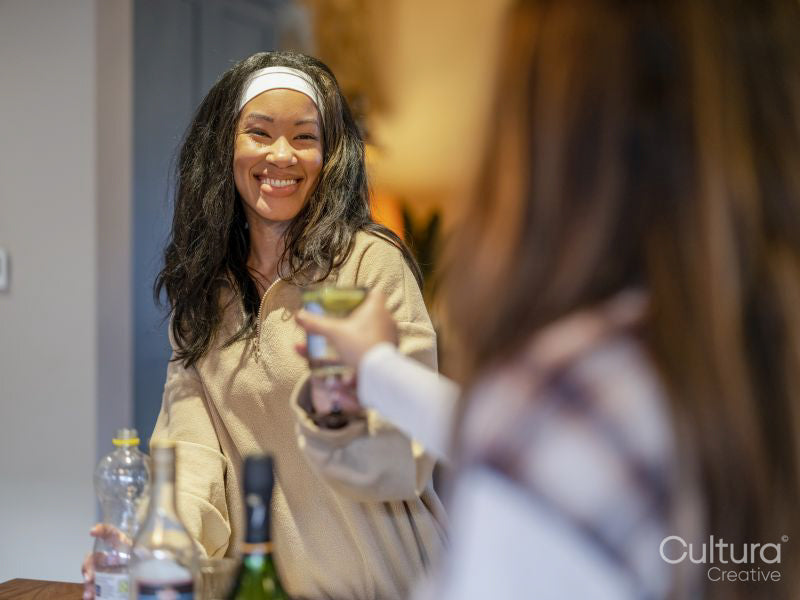 Female friends making celebratory toast at home