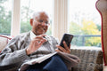 Smiling senior man using smart phone
