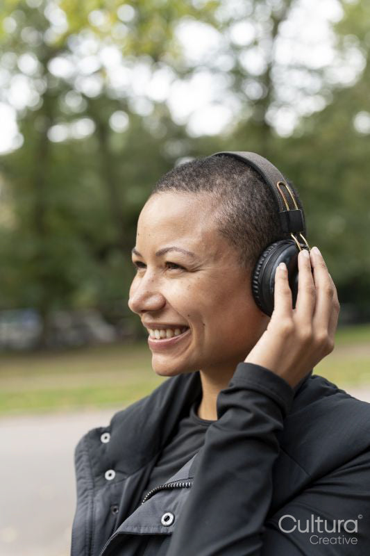Smiling woman with headphones in park