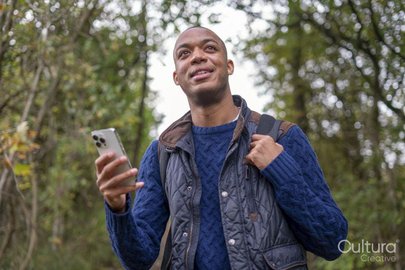 Man holding smart phone during nature walk in autumn