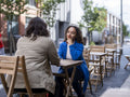 Smiling couple sitting at sidewalk cafe table