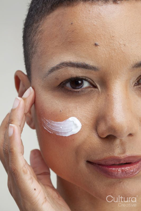Close-up of woman applying facial cream