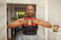 Mature woman exercising at home with dumbbells