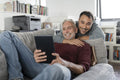 Smiling male couple using digital tablet on sofa