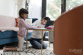 Two sisters doing homework in living room