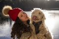 Young woman holding dog at lake