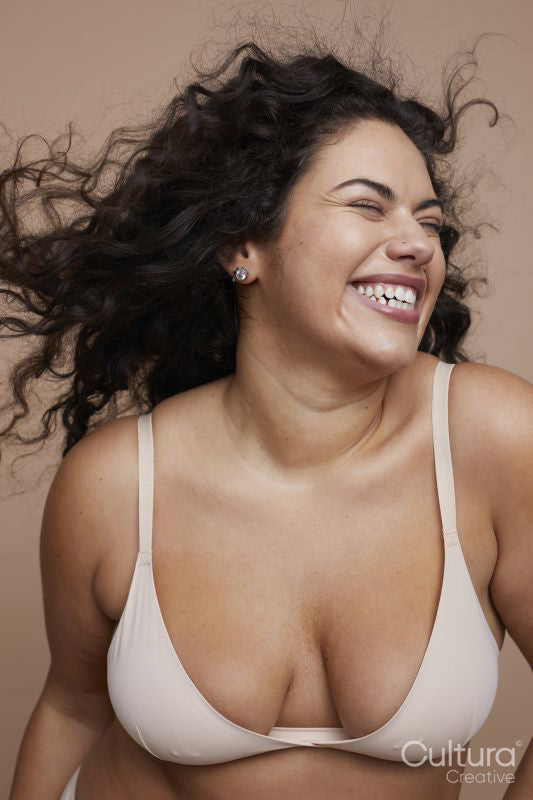 Studio shot of smiling young woman with curly hair