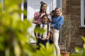 Portrait of mothers and sons in front of house
