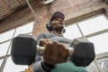 Low angle view of woman exercising with dumbbells at gym