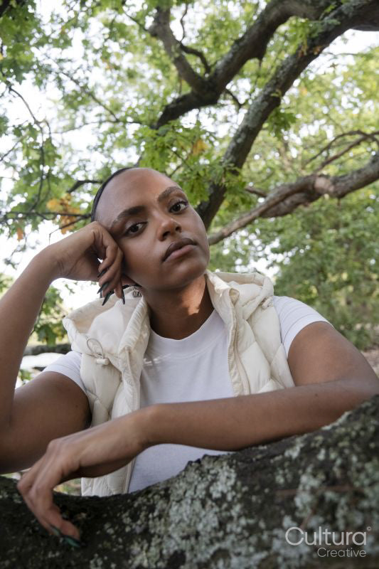 Portrait of pensive woman leaning on tree branch