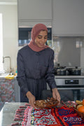 Smiling woman in hijab putting food on table
