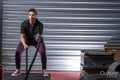 Athletic woman exercising with battle ropes at gym