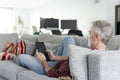 Smiling mature man using digital tablet on sofa