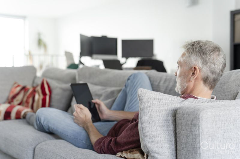 Smiling mature man using digital tablet on sofa